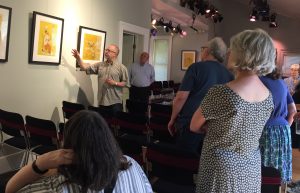 David Hile discussing a drawing at his art exhibition